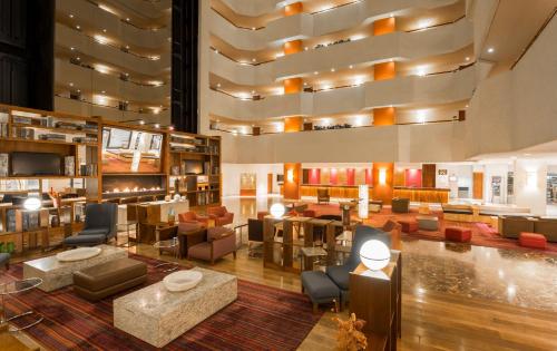 a lobby with couches and chairs and a library at Camino Real Aeropuerto in Mexico City