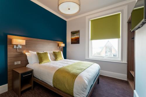 ein Schlafzimmer mit einem großen Bett und einem Fenster in der Unterkunft St Andrews Hotel in Exeter