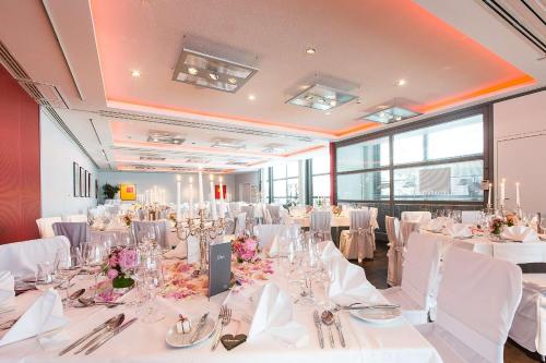 a large room with white tables and chairs with white tablecloths at Arthotel Heidelberg in Heidelberg
