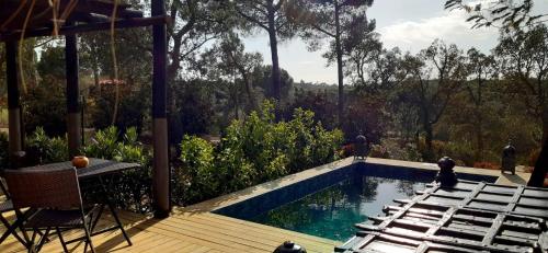 a swimming pool with chairs next to a deck at Ying Yang Monte da Lua in Comporta