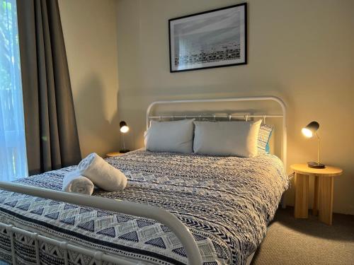 a bedroom with a bed with white sheets and pillows at Colonial Village Resort in Hervey Bay