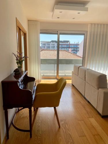 a living room with a piano and a couch at Apartamento O Albuquerque - Centro Cidade Alcobaça in Alcobaça