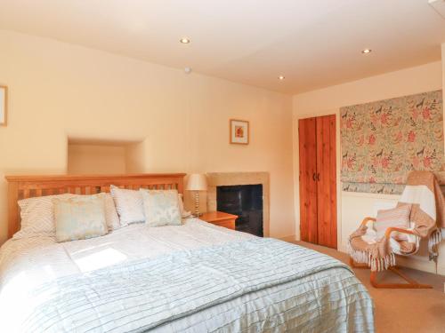 a bedroom with a large bed and a fireplace at Manna Cottage in Grassington