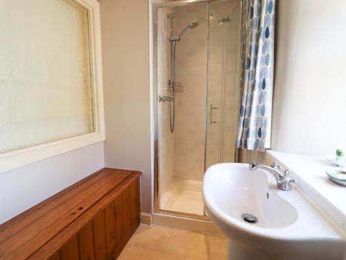 a bathroom with a shower and a sink and a sink at Manna Cottage in Grassington