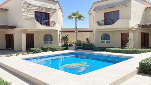 a villa with a swimming pool in front of a house at Villa Sonari 4, Inside a private complex of 4 By Kivoya in Puerto Peñasco