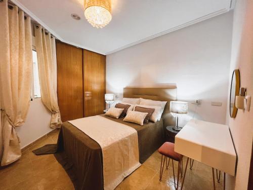 una camera con letto, tavolo e scrivania di Holiday Suite Fragata a Torrevieja