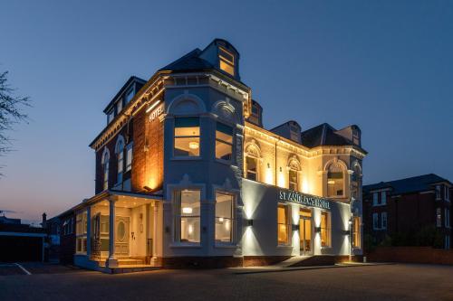 a large building with lights on the side of it at St Andrews Hotel in Exeter
