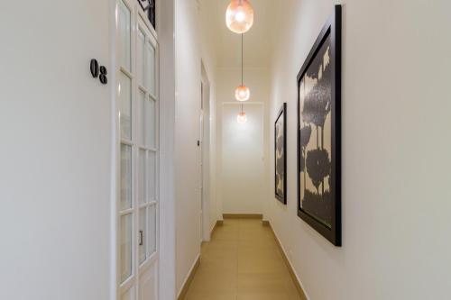 a hallway with paintings on the walls and a hallway with a hallwayngth at Hotel Republicano 1910 in Girardot