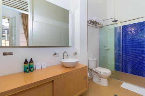 La salle de bains est pourvue d'un lavabo, de toilettes et d'un miroir. dans l'établissement Hotel Republicano 1910, à Girardot