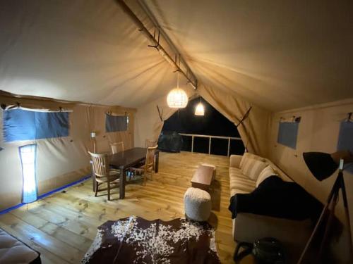 a room with a tent with a table and a couch at Lynx Lodge in Waipapa