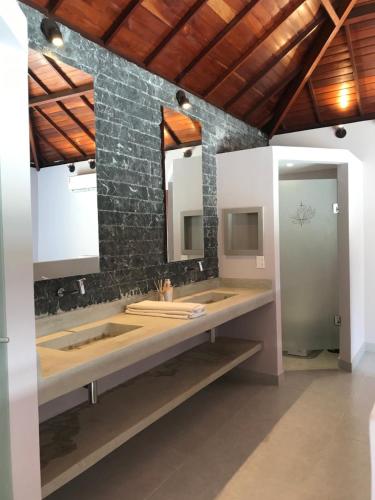 a bathroom with two sinks and two mirrors at Vila Palmeiras in São Miguel do Gostoso