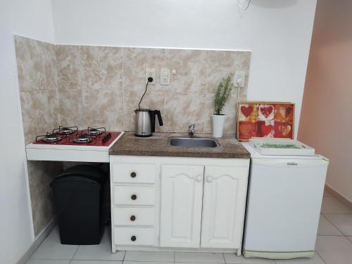 a small kitchen with a sink and a stove at Departamento Temporario in Resistencia
