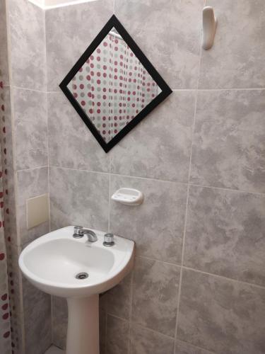 a bathroom with a sink and a mirror on the wall at Departamento Temporario in Resistencia