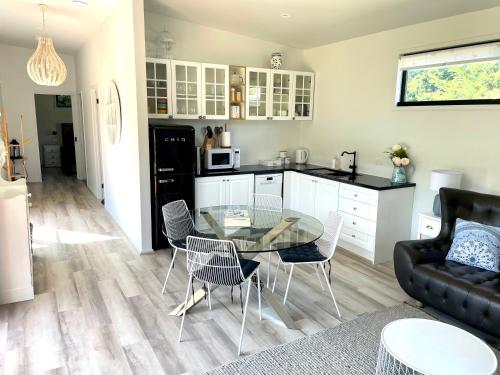 a kitchen and living room with a glass table and chairs at Farm Stay POPLAR Cottage at Wilindi Estate in Tyabb
