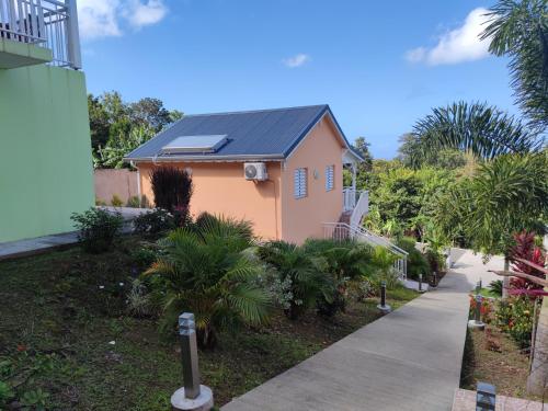 a small house with a solar roof on a sidewalk at Gîte Zozio Kréyol in Pointe-Noire