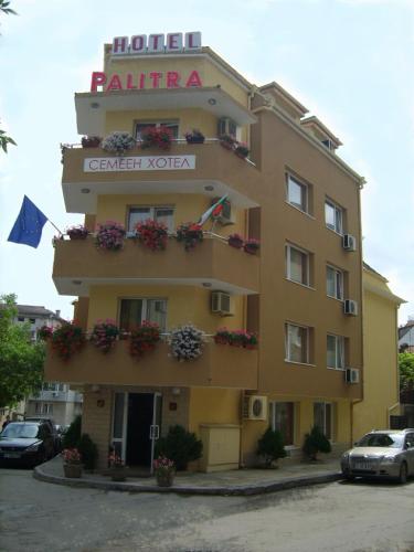 a large yellow building with a sign on it at Hotel Palitra in Varna City