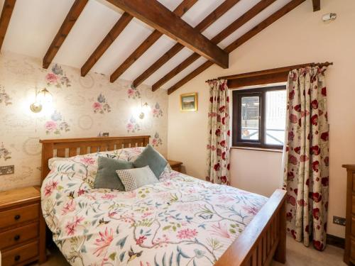 a bedroom with a bed and a window at Heath Cottage in Edale