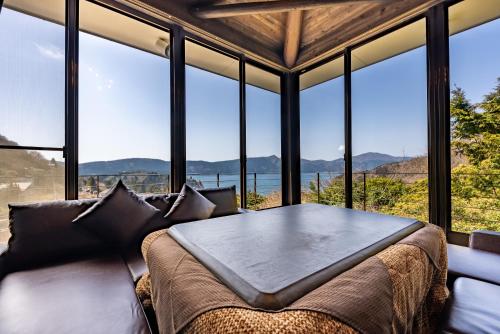 a room with a table and chairs in front of windows at VILLA HAKONE湖空 in Hakone
