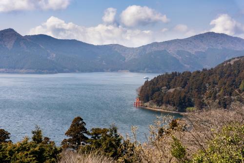 a barge in a large body of water with mountains at VILLA HAKONE湖空 in Hakone