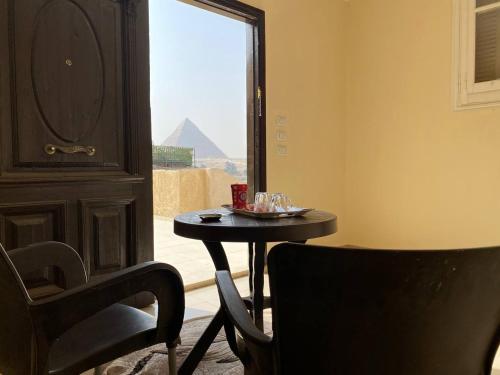 uma mesa e uma cadeira num quarto com uma janela em Capo Pyramid no Cairo