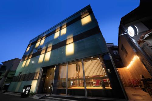 a glass building with a clock on the side of it at Andon Ryokan in Tokyo