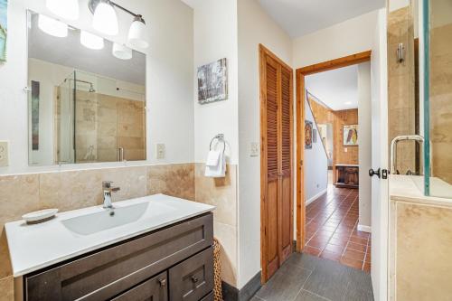 een badkamer met een wastafel, een douche en een spiegel bij Starboard Sunset in Bodega Bay