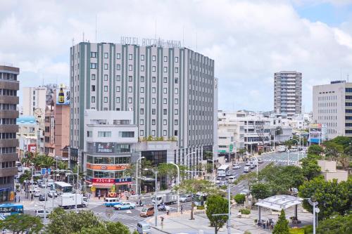 miasto z wysokim budynkiem i ulicą z samochodami w obiekcie Hotel Rocore Naha w mieście Naha