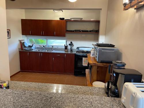 a kitchen with wooden cabinets and a counter top at Villa Solara 6 - Luxury 6 Bedroom Villa with Pool, Golf & Lake View in Río Hato