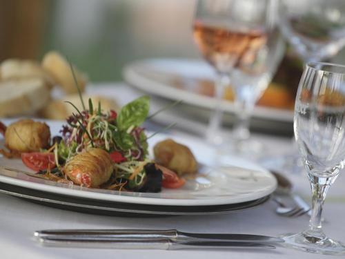a plate of food on a table with wine glasses at Badhotel Restaurant Stauferland in Bad Boll