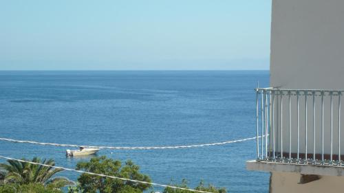 a boat on the water next to a lighthouse at La Casa del Pescatore in Filicudi