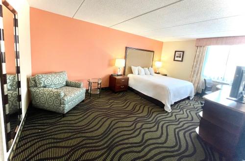 une chambre d'hôtel avec un lit et une chaise dans l'établissement Fairbridge Hotel Cleveland East, à Wickliffe
