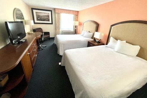 a hotel room with two beds and a television at Fairbridge Hotel Cleveland East in Wickliffe