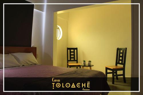 a bedroom with a bed and two chairs and a table at CASA TOLOACHE in Oaxaca City