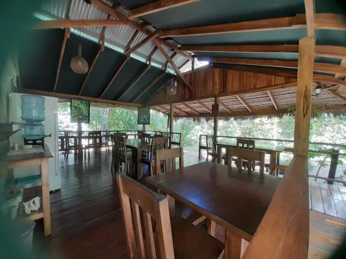 uma sala de jantar com mesas e cadeiras de madeira em Hidden Paradise Lodge em Drake