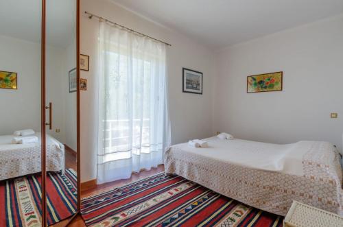a bedroom with two beds and a large window at Apartment VILA GRSCICA in Blato