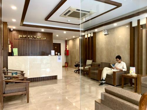 a man sitting on a couch in a lobby at HOTEL Blue Rose in Hai Phong