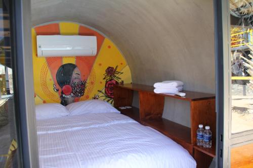 a room with a bed with a painting on it at ChangoMango in La Ventana