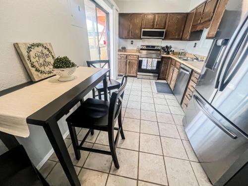 een keuken met een tafel en stoelen en een koelkast bij Lovely 2 bedroom! Close to All in a 4Plex in Colorado Springs