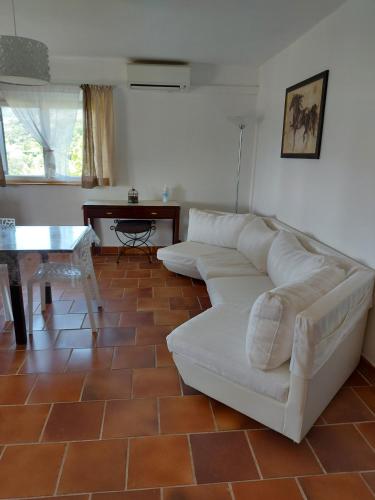 a living room with a white couch and a table at Superbe maison entière villa les pinsons in Emponse