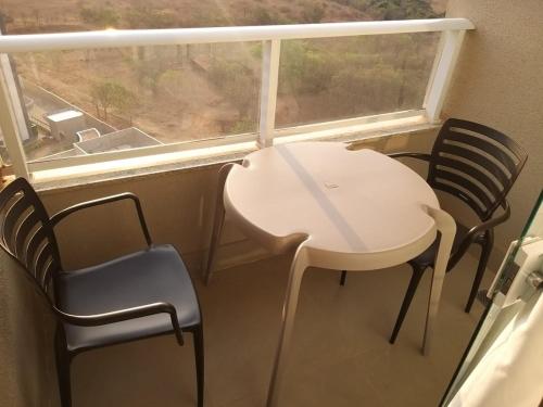 a white table and chairs in a room with a window at APARTAMENTO OLIMPIA SOLAR DAS AGUAS in Olímpia