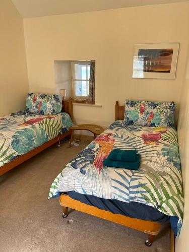 a bedroom with two beds and a window at The Old Ferryhouse in Port Appin