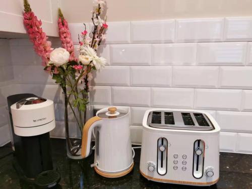 a kitchen counter with a toaster and a vase of flowers at Your Perfect Waterfront Escape in Bar Point