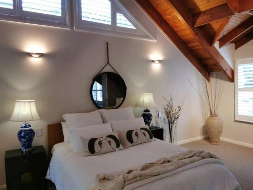 a bedroom with a large white bed with a mirror at Your Perfect Waterfront Escape in Bar Point