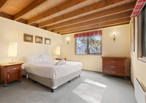 a bedroom with a large bed and a window at Caribou in Dinner Plain