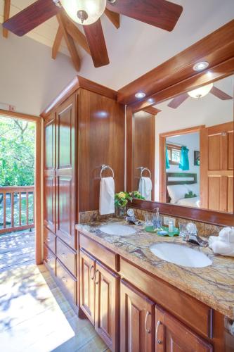 a bathroom with a sink and a large mirror at Mariposa Belize Beach Resort in Placencia Village