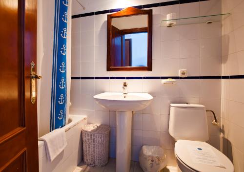 a bathroom with a sink and a toilet and a mirror at Hotel Atalaya in San José