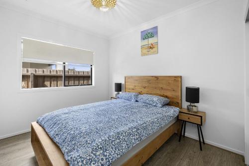 a white bedroom with a bed and a window at Lowtide Five Bedroom 22 in Torquay