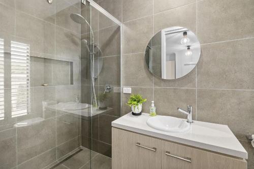 a bathroom with a shower and a sink and a mirror at Lowtide Five Bedroom 22 in Torquay