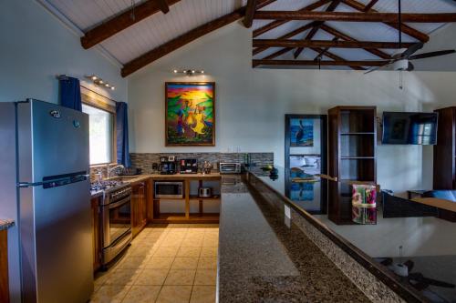 a kitchen with a stainless steel refrigerator and counters at Mariposa Belize Beach Resort in Placencia Village