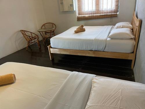 two beds in a room with a teddy bear sitting on them at Layang Layang Guest House Melaka in Melaka